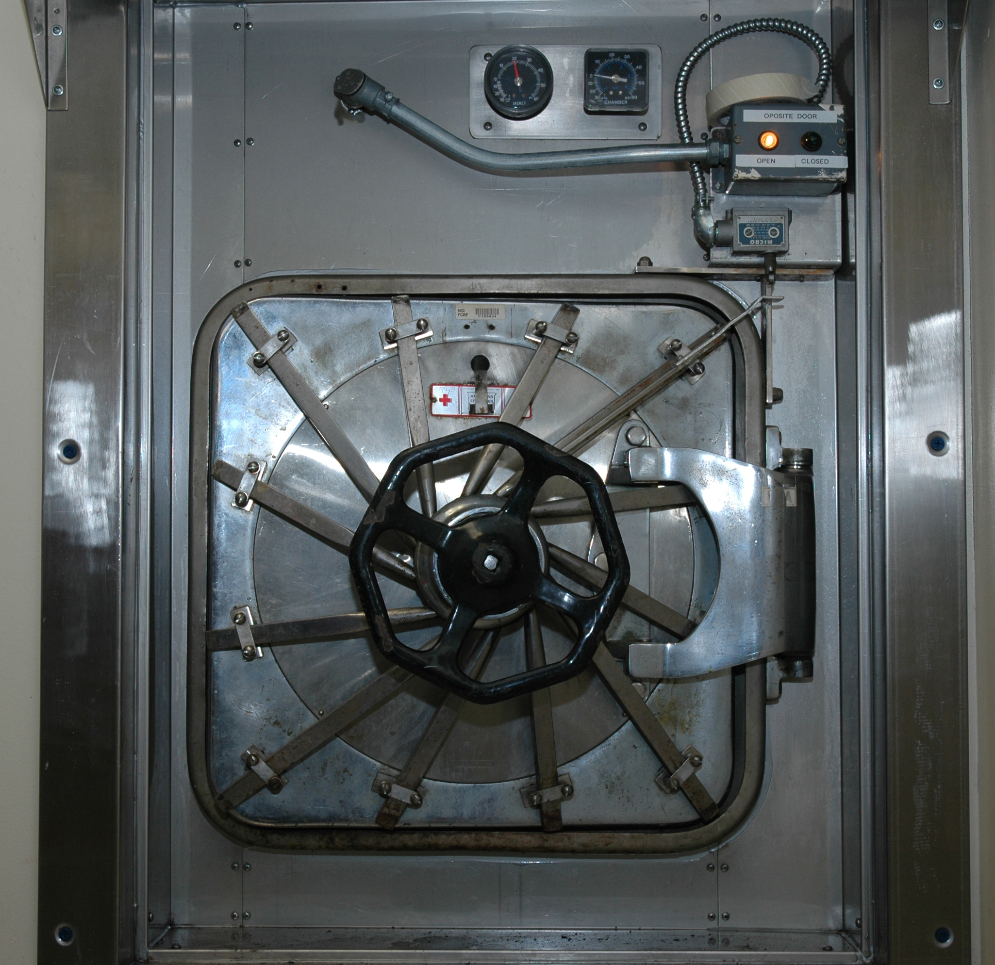 Steel autoclave chamber door with wheel handle and pressure gauges